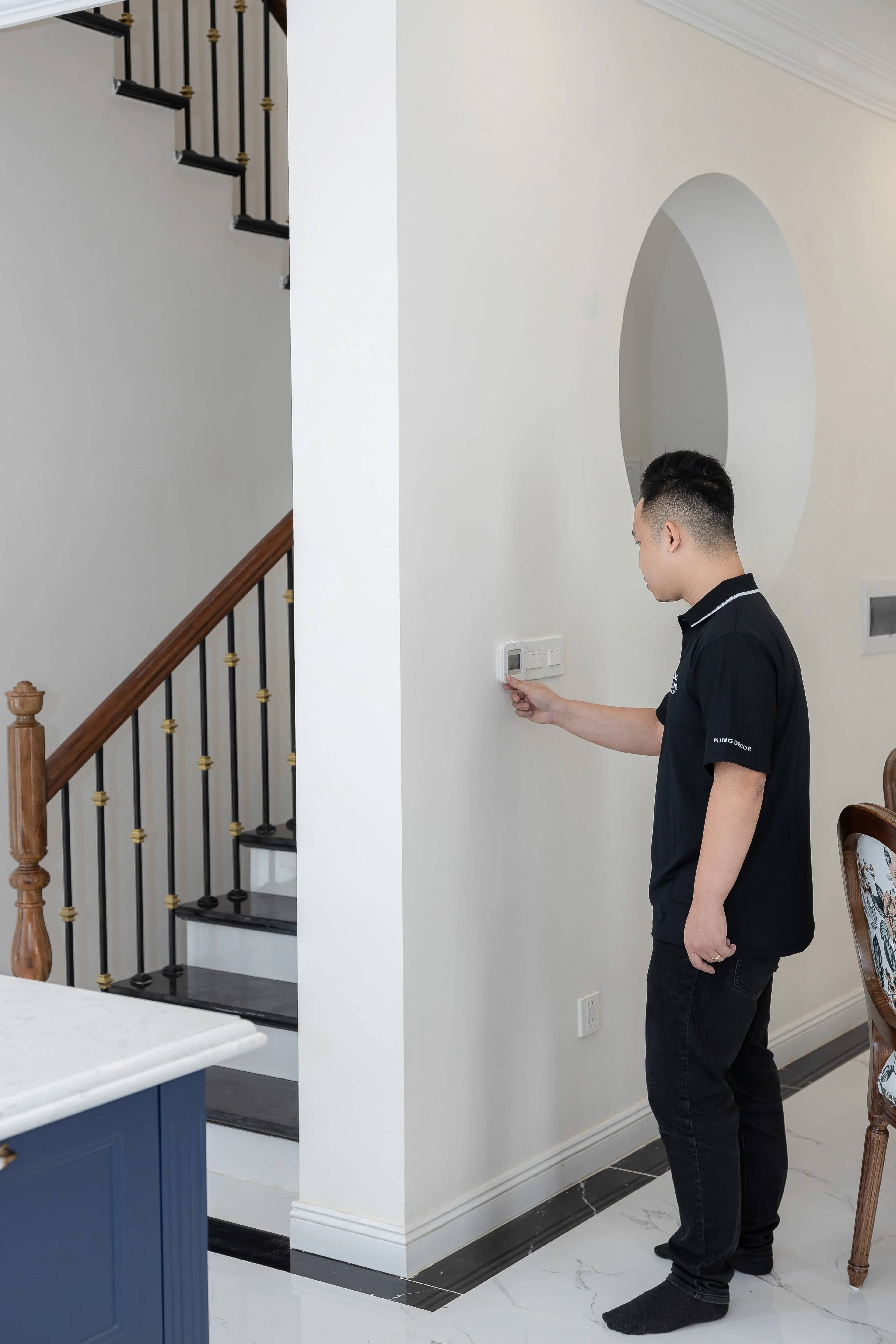 Homeowner adjusting a thermostat on the wall